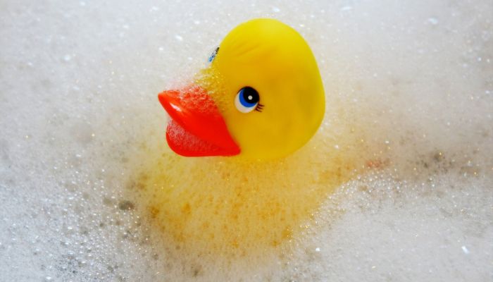 rubber duck in soapy bathtub