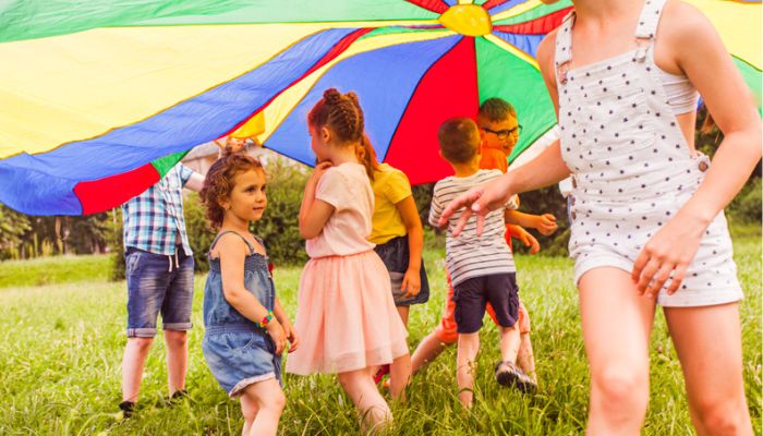 Kids playing under a parachute