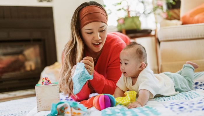 mother and infant tearing and unwrapping paper